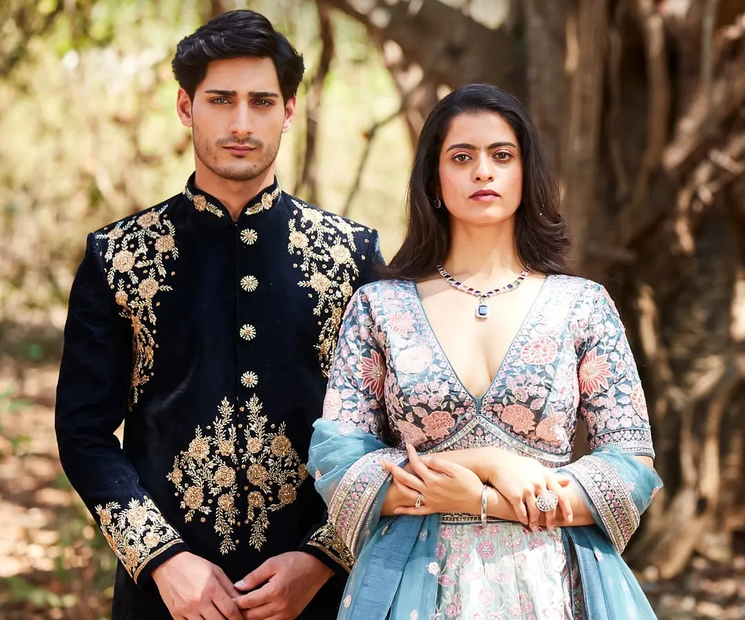 Power couple goals, sorted. I love styling couples to complement each other perfectly. Here, his rich, gold-embroidered black velvet sherwani stands next to her elegant floral lehenga, creating a look that’s both coordinated and individually striking.