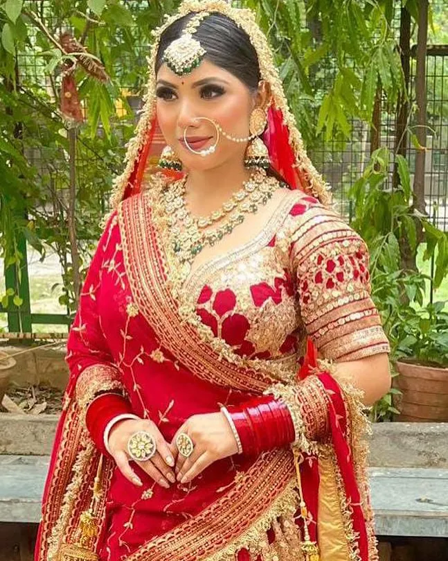 A close-up of my classic HD bridal makeup. I focus on creating a flawless, radiant base that looks stunning in photos and lasts all day. Notice the defined eyes and perfectly blended skin, creating a timeless look for this beautiful bride in her red lehenga.