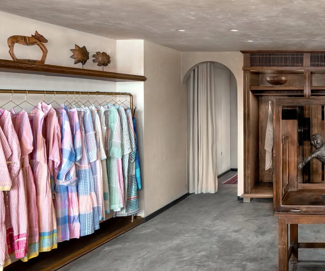 For the Eka fashion boutique in a Mumbai heritage building, we embraced a narrative of nostalgia and comfort. This space balances raw concrete floors with the warmth of natural wood displays and custom almira-style wardrobes, creating an intimate, home-like feel that reflects the brand's timeless values.
