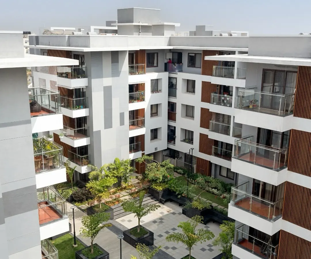 An aerial perspective of the Sona Vistaas residential cluster in Bengaluru, where buildings are organized around a central, verdant courtyard. This layout is a core principle of my township planning, designed to enhance microclimates and create a shared sense of place.