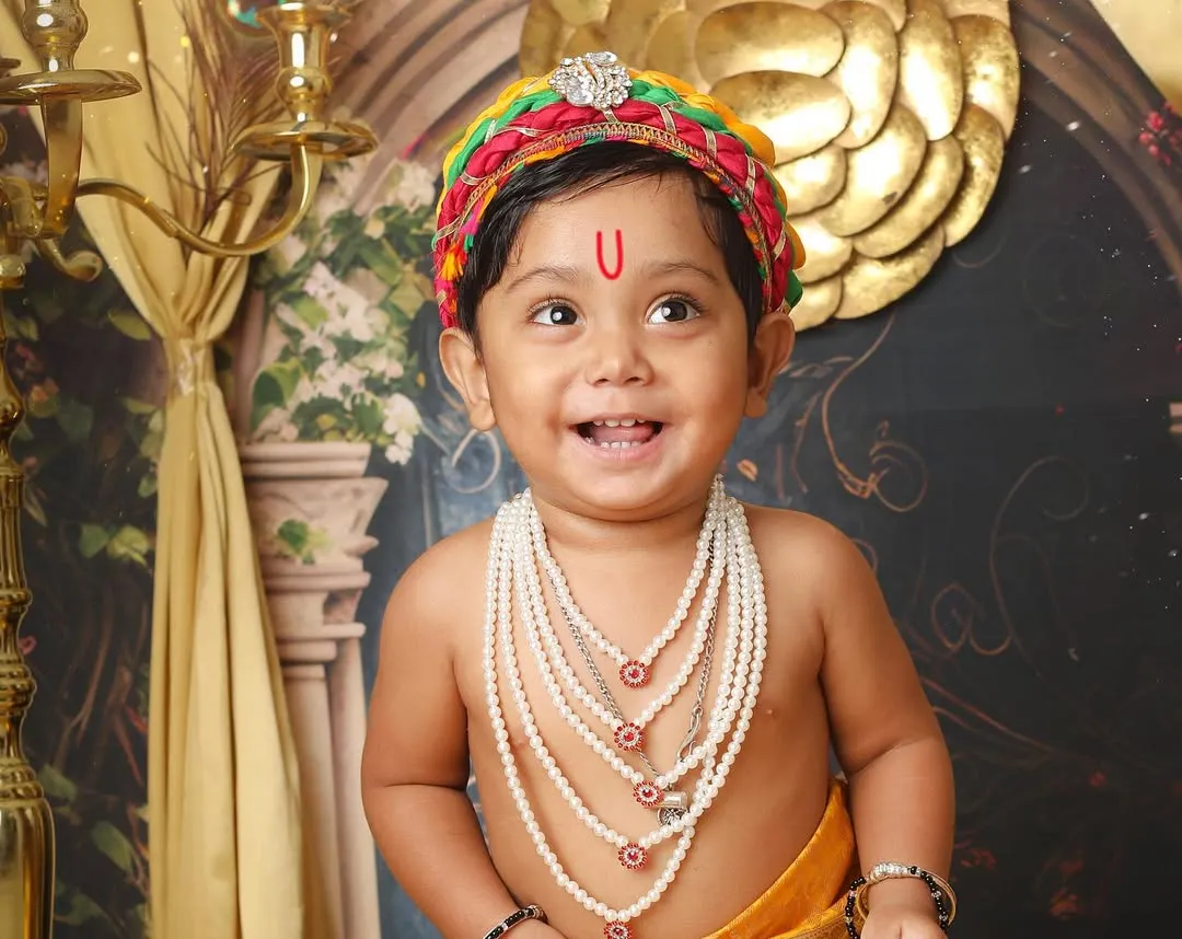 The pure, innocent smile of a little one dressed as Kanha is truly divine. This close-up from a Janmashtami themed shoot captures the joyful spirit that makes these sessions so special.