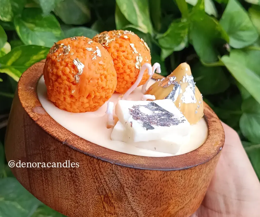 I love bringing a playful touch to tradition with my Indian dessert platter candles. This piece features realistic-looking laddoo, modak, and kaju katli candles, all made from scented soy wax and arranged in a beautiful wooden bowl.