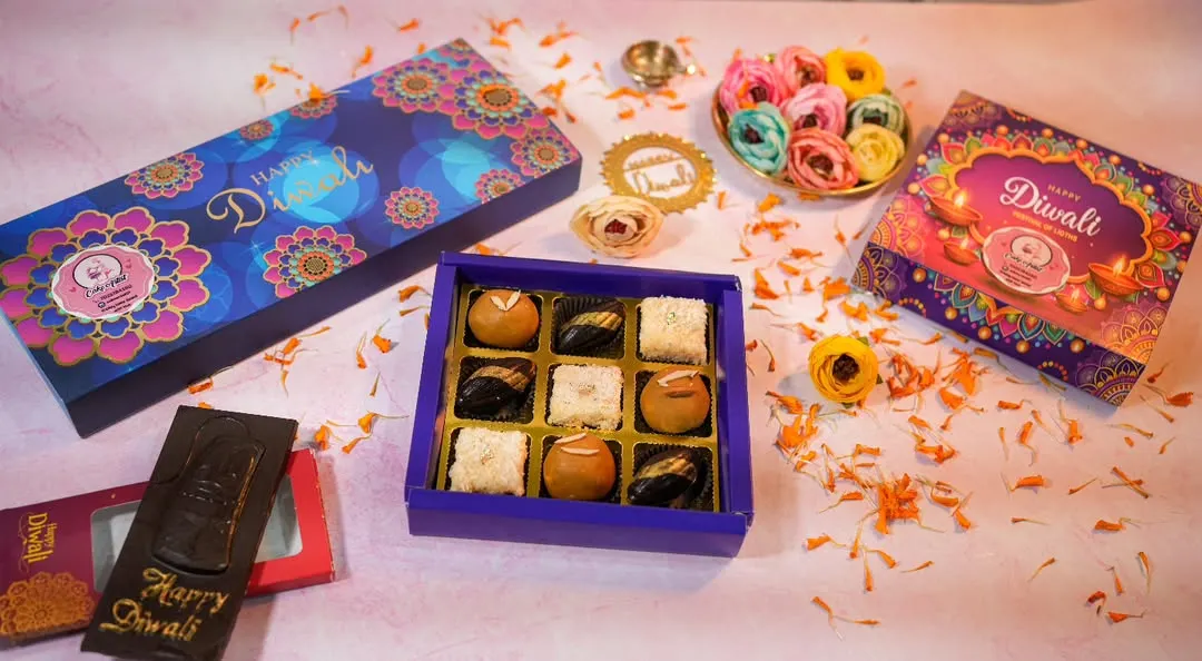 Getting into the festive spirit with my Diwali hampers. ✨ This shot shows some of my bestselling eggless treats, like assorted chocolates and sweets, all packed in these beautiful, vibrant boxes. Perfect for gifting to family, friends, or colleagues.