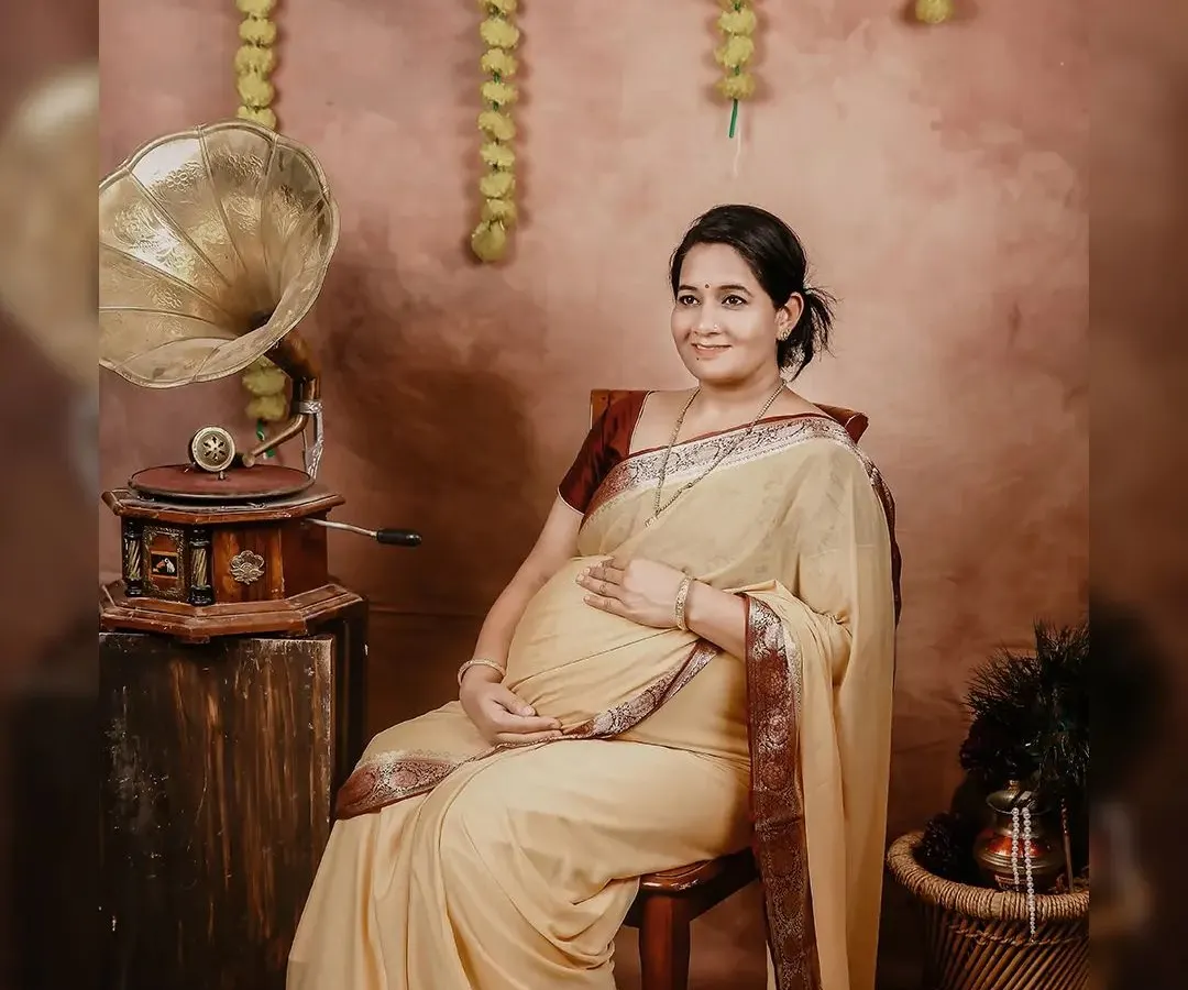 A serene portrait from one of our traditional maternity sessions. The combination of a beautiful cream saree, marigold flowers, and vintage props creates a truly timeless feel.