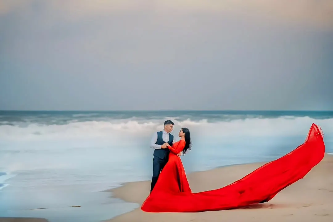 The drama of the sea meets the elegance of this flowing red gown. For this beach pre-wedding shoot, I wanted to create a powerful, vibrant image that felt both romantic and epic. The contrast of the red against the moody sky and waves makes this a standout shot.