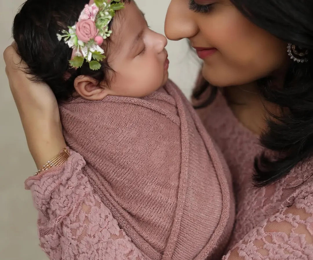 A tender close-up from a newborn photoshoot, capturing the delicate features of the baby and the mother's loving gaze. These quiet moments are so precious.