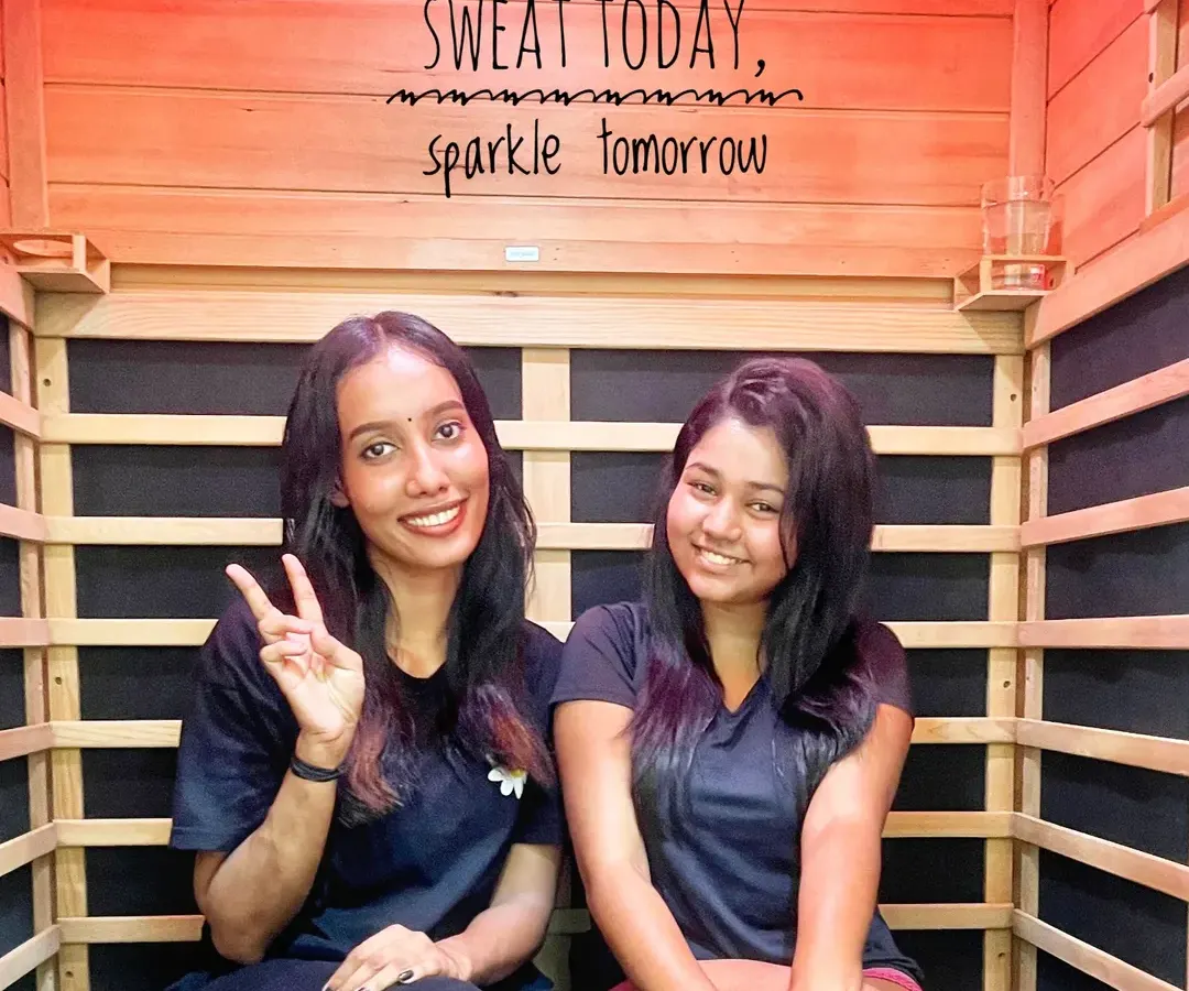 Sweat today, sparkle tomorrow. Here you can see two clients enjoying the gentle warmth of our private infrared sauna cabin. The experience is designed to boost circulation and detoxify your skin from the inside out, leaving you with a healthy glow.