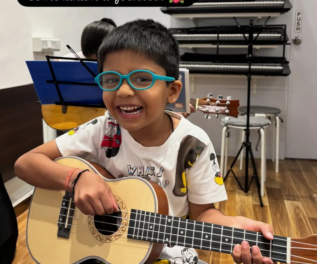 Look at that smile. The ukulele is such a happy instrument, and this is the pure joy I aim for in my classes. This image captures the moment a child connects with music, and the call to action invites other kids to experience it for themselves.