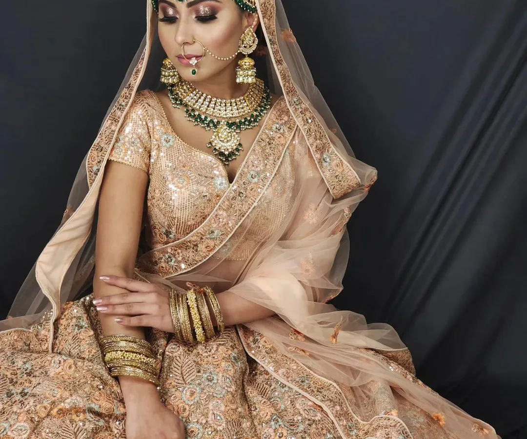 For the modern bride, this pastel peach lehenga is a dream. It’s paired here with a contrasting green Kundan jewellery set, showing how you can mix and match pieces at my studio to create a unique look.