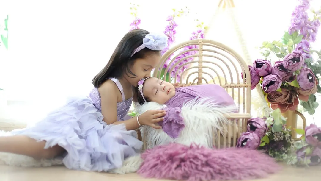 Welcoming a new baby is a joy for the whole family. I love creating these gentle portraits that capture the beginning of a lifelong bond between siblings, surrounded by a soft, dreamy floral setup.