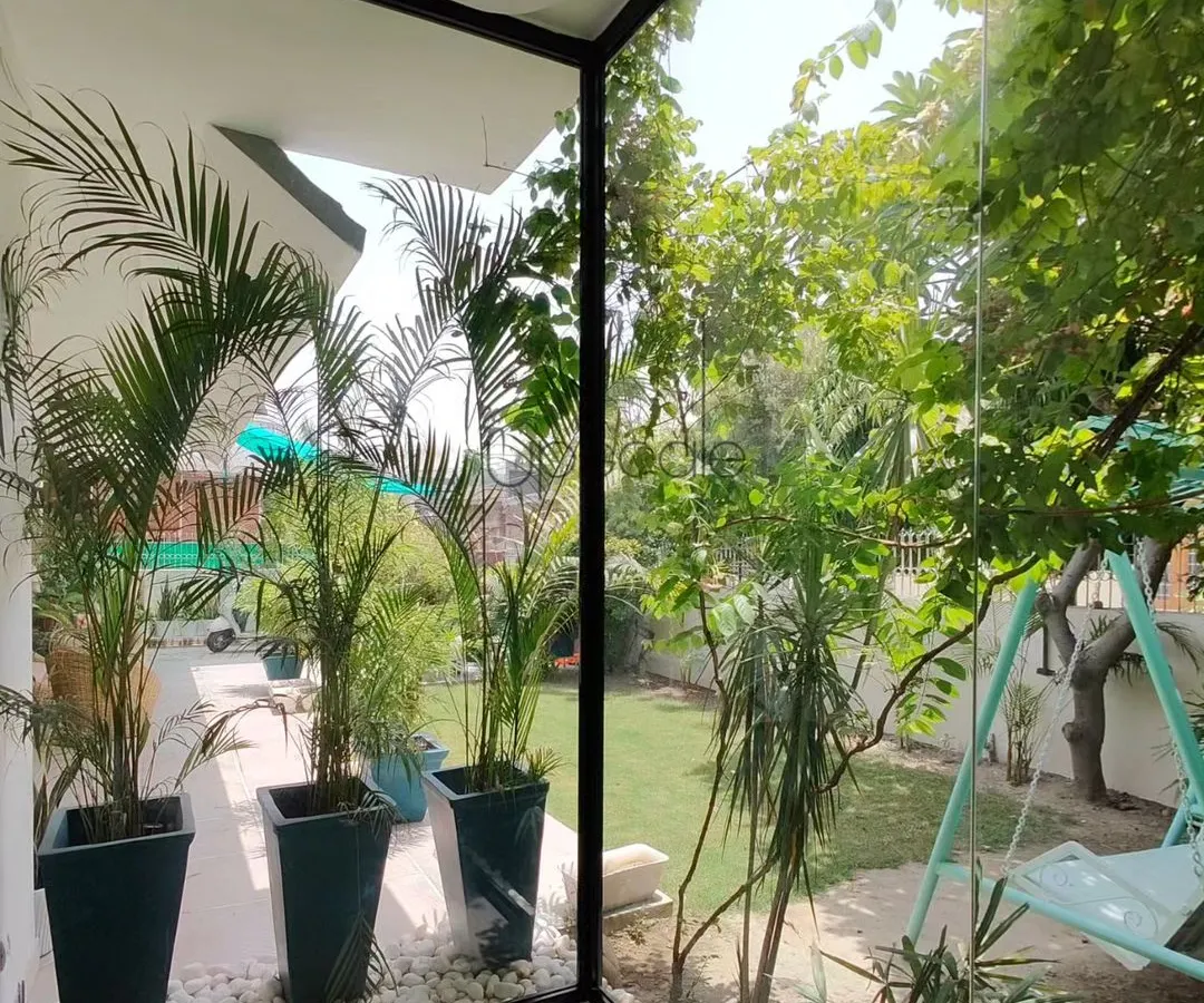 A corner of our own office, designed to prove that a connection to nature is essential for a productive and peaceful workspace. The floor to ceiling glass walls erase the boundary to the garden, making the lush greenery and natural light a core part of the indoor experience.