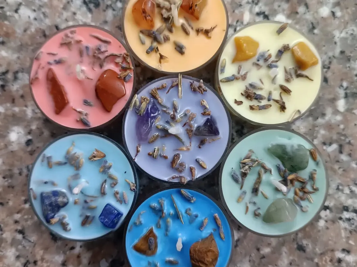 This is my popular 7 Chakra healing candle set, shown here as tealights. Each candle is colored and infused with a specific crystal and botanical blend, like lavender, to correspond with each chakra for balancing rituals.