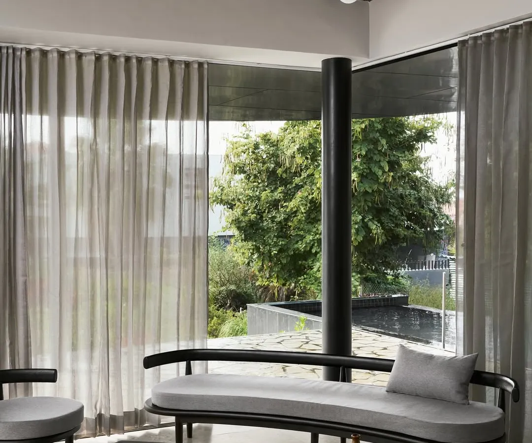 For the Pavilion House, we designed a serene retreat that merges with the landscape. This living area showcases our minimalist aesthetic, using a monochrome palette, curated black wood furniture, and expansive glass walls to create a tranquil space for contemplation and connection with nature.