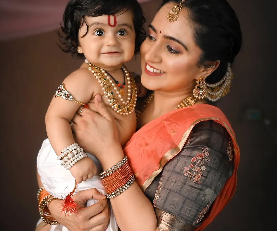 A tender moment between a mother and her little Kanha. For my cultural and festive photoshoots, I provide authentic traditional outfits and detailed backdrops to create timeless, artistic portraits like this one.