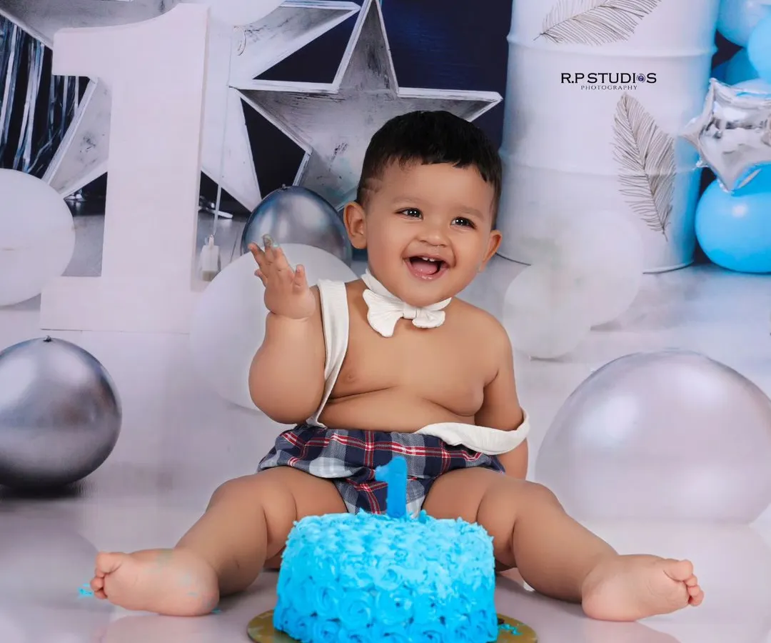 The pure joy of a first birthday is captured in this cake smash session. This little boy's infectious laugh and messy hands are the perfect representation of a milestone celebrated with fun and sweetness.