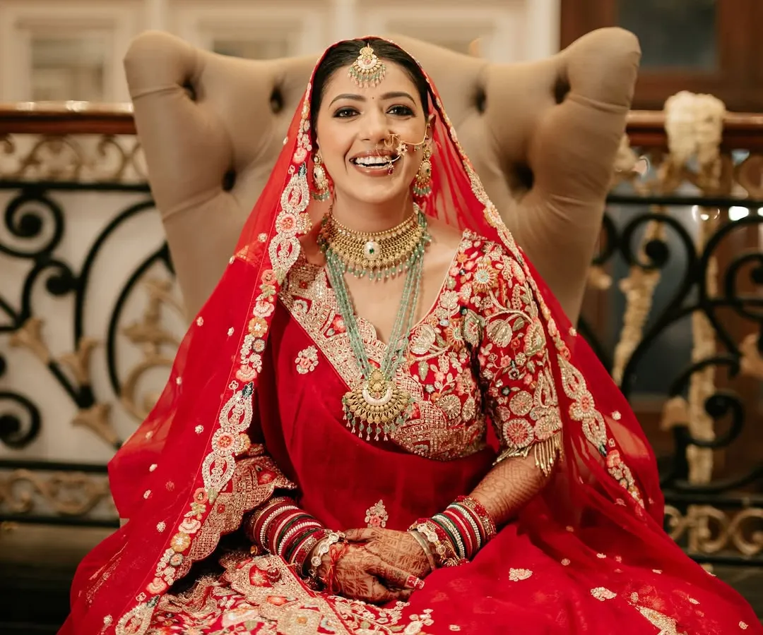 That priceless smile of a happy bride is what I live for. For Sona, we went with a classic red lehenga look, focusing on radiant skin and eyes that sparkle, making her look absolutely breathtaking in her wedding photos.
