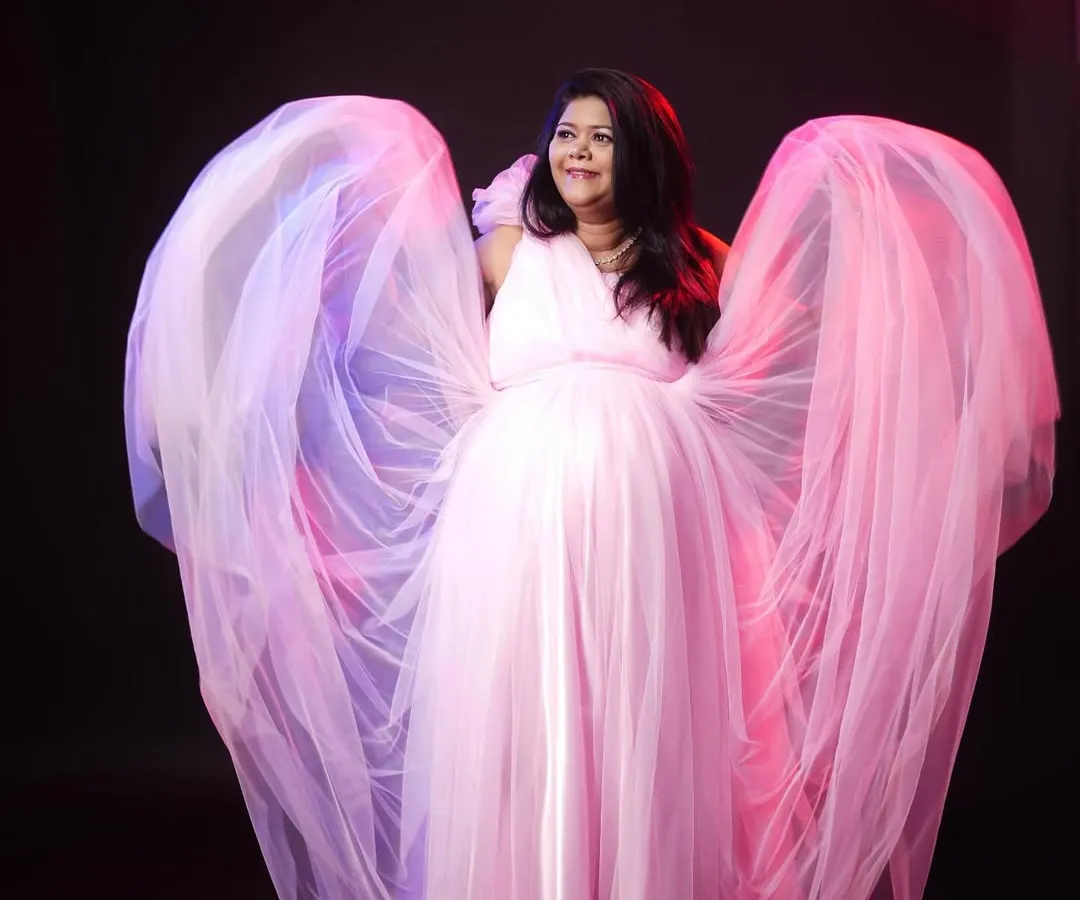 For a touch of magic, I use lighting and flowing fabrics to create dramatic, angel-like portraits. This pink maternity gown is a popular rental choice for moms-to-be who want a glamorous look.