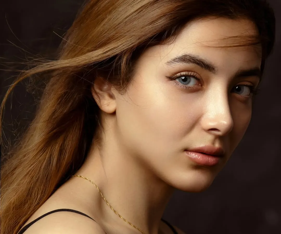 This is where simplicity meets soul. A classic studio headshot where the focus is entirely on the subject's expressive eyes and serene confidence, captured with soft, cinematic lighting.