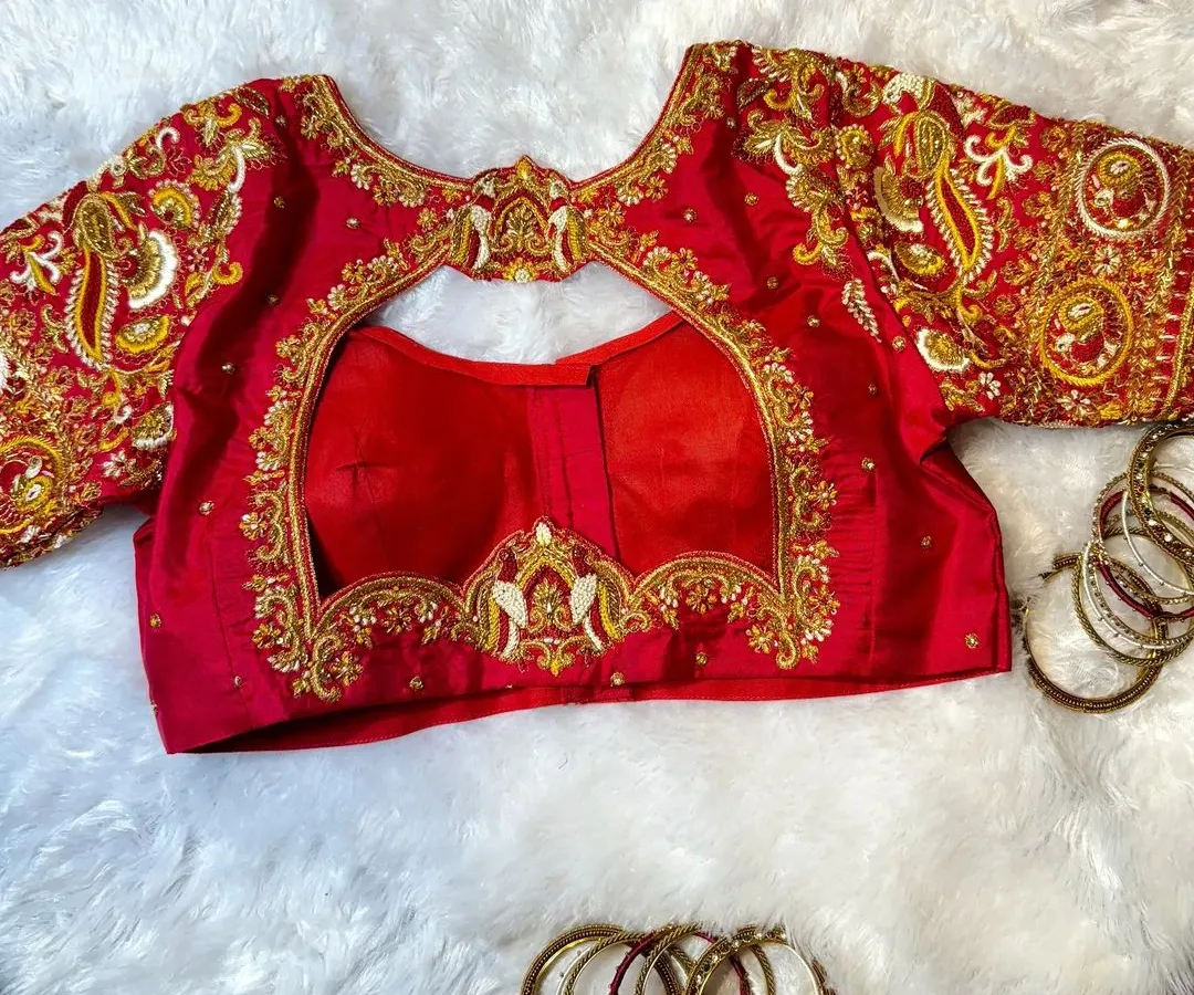 I love bringing symbolic designs to life, like the bird motifs on this classic red bridal blouse. This piece showcases detailed zardosi and French knot embroidery, a testament to the handwork that goes into every creation.