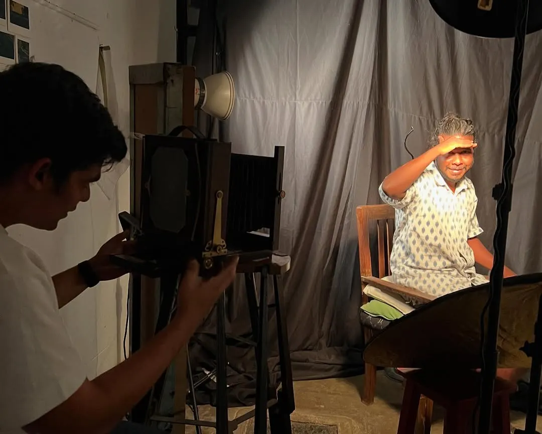 Your portrait session is a slow, deliberate experience. Here, I am working with a client in the studio, using a large format vintage camera to compose the shot. It's a collaborative process, far from the rush of digital photography.