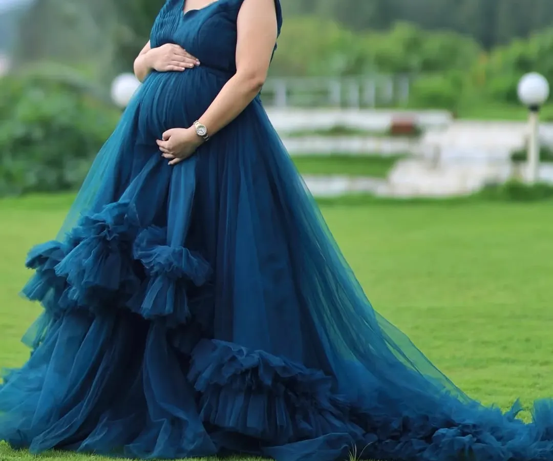 My maternity gowns are designed to make you feel beautiful and comfortable. This turquoise gown features a long, flowing tail and soft ruffle details, perfect for capturing this special time. It's also a convertible dress that can be worn as a shorter frock.