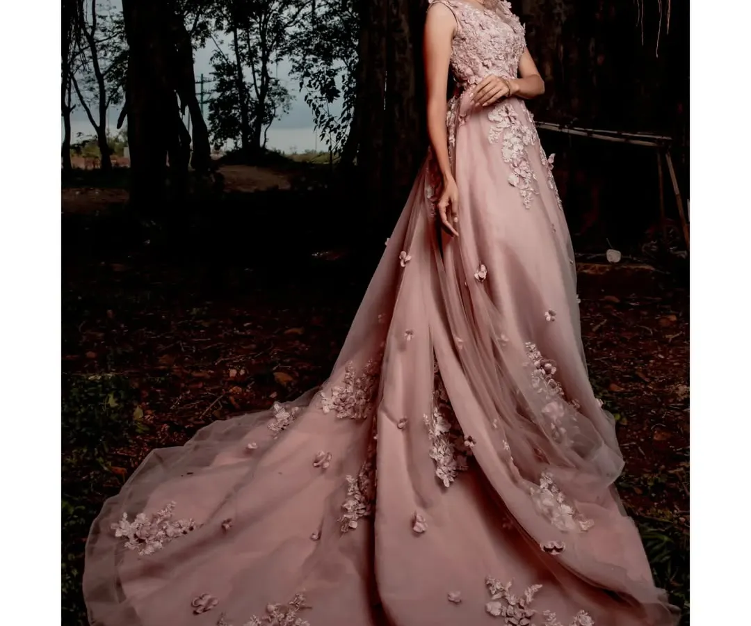This light pink floral appliqué gown is a fairytale moment waiting to happen. Its magnificent train creates breathtaking photos, making it a perfect choice for a pre-wedding shoot or a grand reception entrance.
