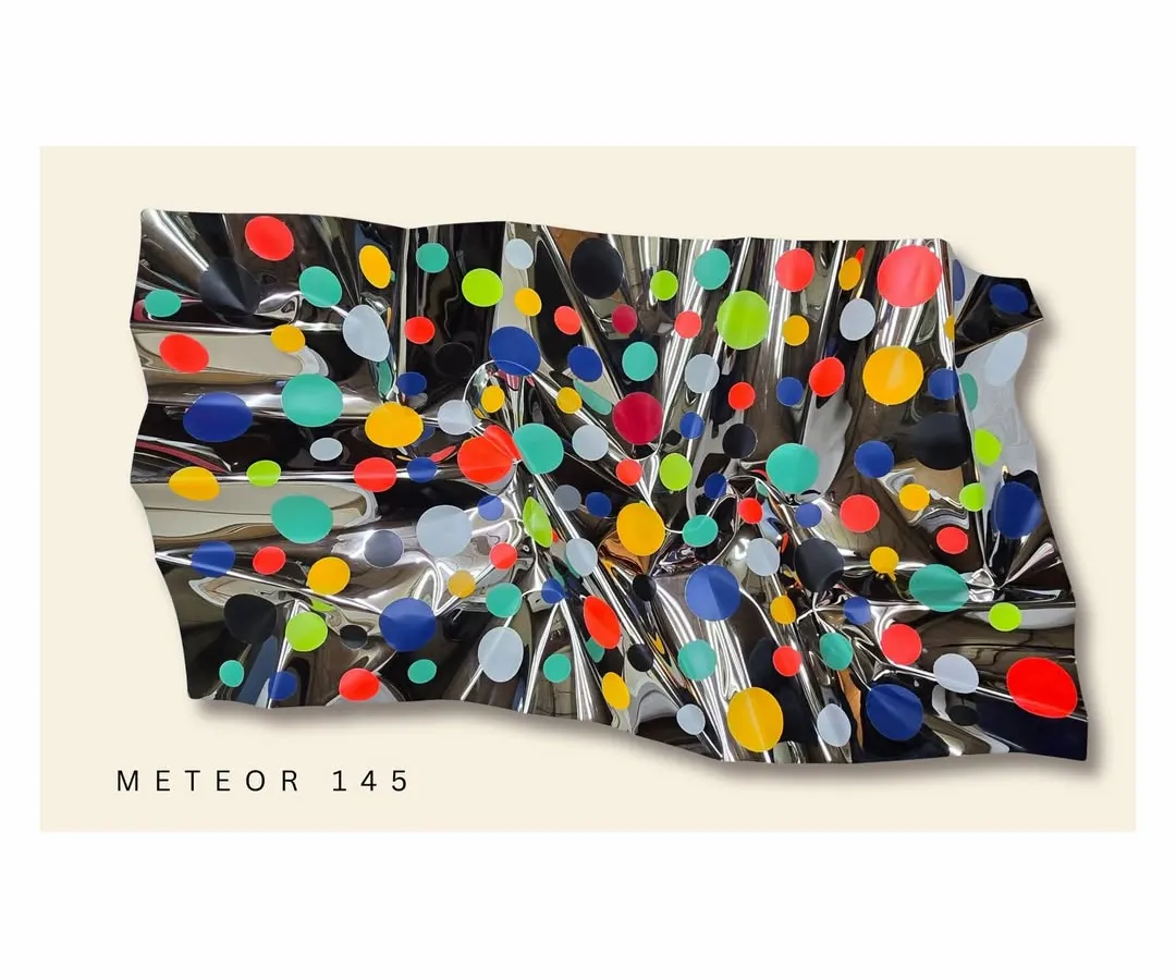 From my Meteor series, this wall installation explores energy and joy. The reflective, crumpled steel surface is scattered with vibrant polka dots, creating a playful and dynamic piece that interacts with the light in the room.