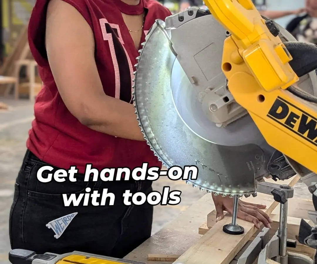 A member gets hands-on experience with a mitre saw, making a precise angled cut on a wooden plank. Our woodworking zone is perfect for everyone, whether you're a complete beginner learning the basics or an experienced crafter working on a complex build.