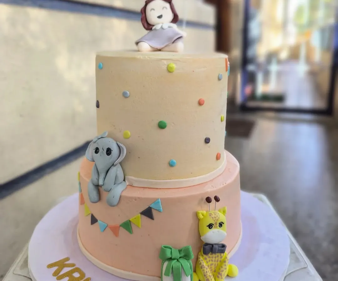 I love bringing imagination to life with cakes like this two-tiered birthday creation. It features adorable, hand-sculpted fondant animals like a baby elephant and giraffe, perfect for a whimsical celebration for your little one.