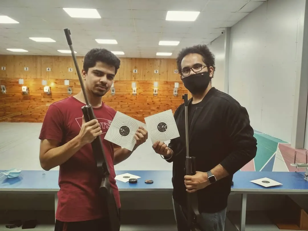 Two of our guests proudly display their target sheets after a successful session. The satisfaction of seeing your shots group together is a key part of the experience we love to share.