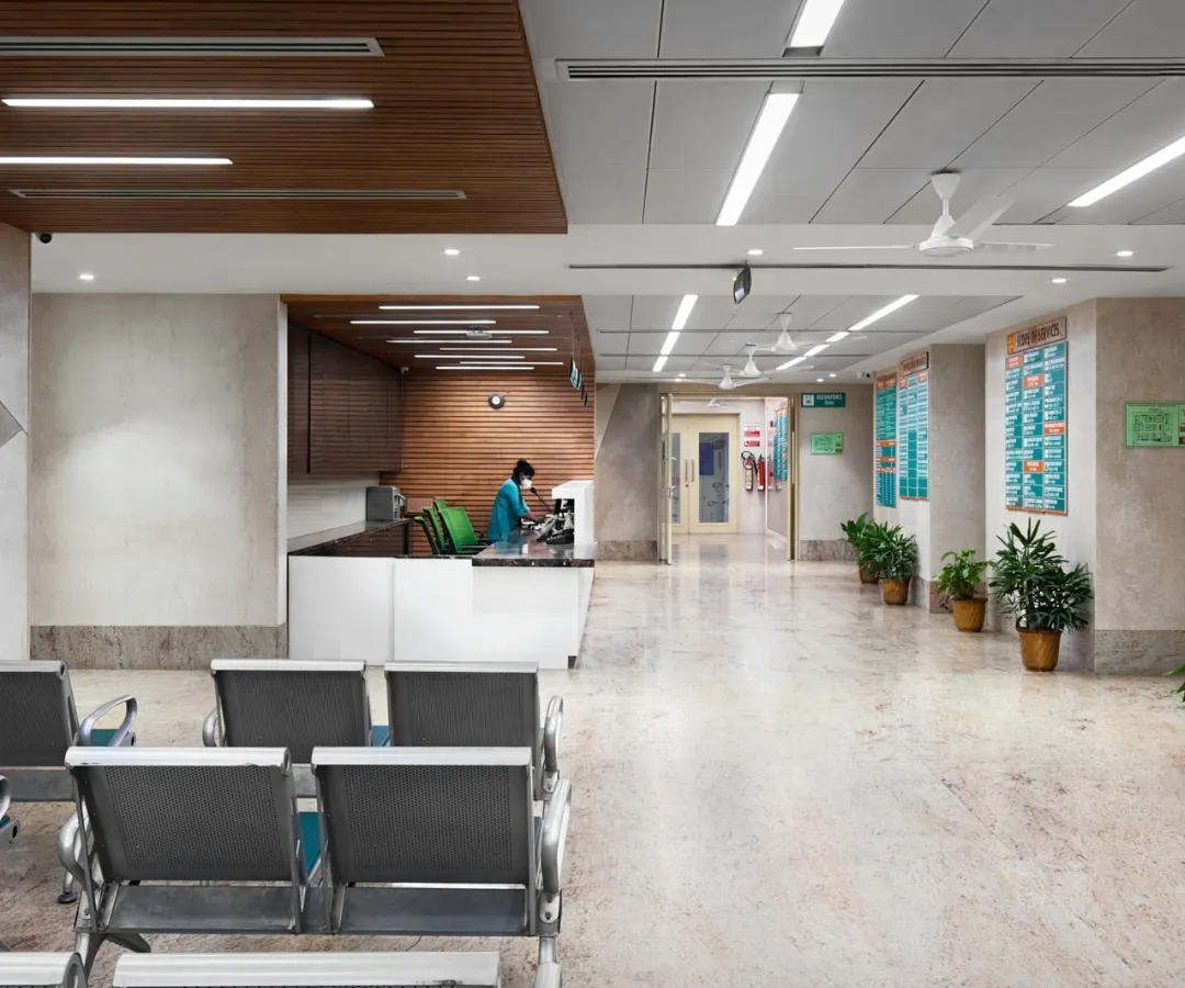 A hospital waiting area should be a space of calm, not anxiety. We achieved this through a clean, intuitive layout, warm materials like the wood-paneled ceiling, and soft, indirect lighting. The design minimizes clutter and noise, creating a serene environment that supports patient well-being from the moment they arrive.