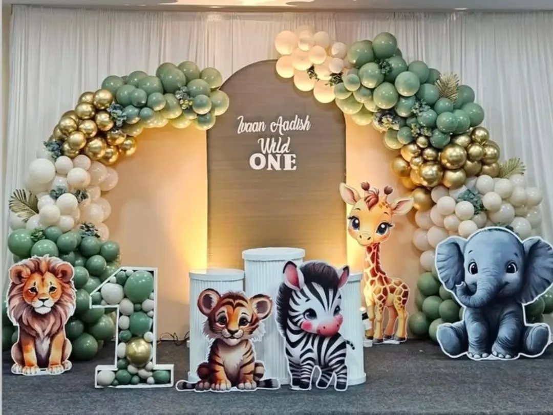 A "Wild One" first birthday party comes to life with a full jungle safari theme. We designed this complete setup featuring a custom backdrop, an organic balloon arch in earthy tones, and adorable animal cut-outs.