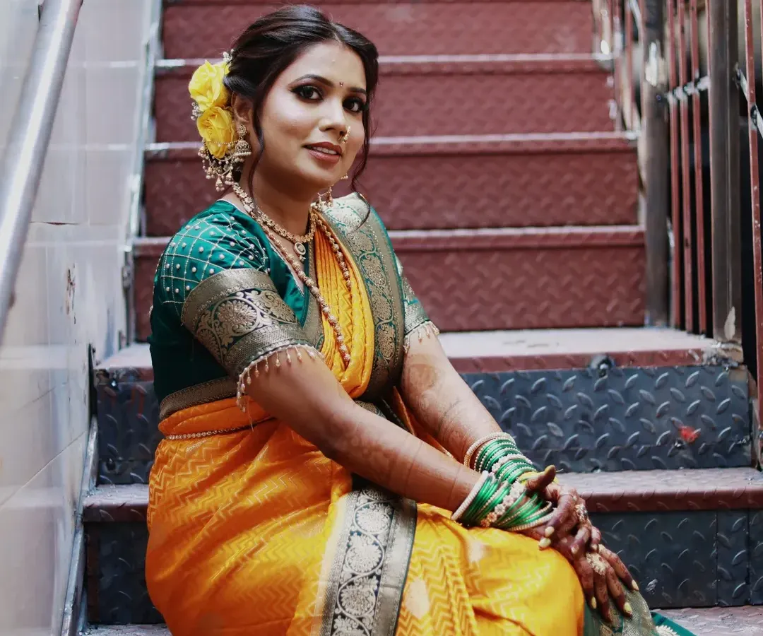 I love creating the perfect Maharashtrian bridal look. Here, I focused on a soft, glowing base to let her natural beauty shine, paired with a classic hairstyle and beautiful yellow flowers. This look is ideal for a traditional wedding ceremony.