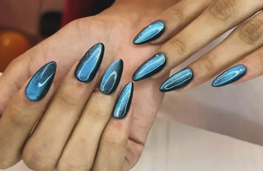 For a bold and mesmerizing look, I use a magnetic cat-eye polish. This set features a stunning blue shade on long almond-shaped nails, creating a deep, shifting shimmer that catches the light from every angle.