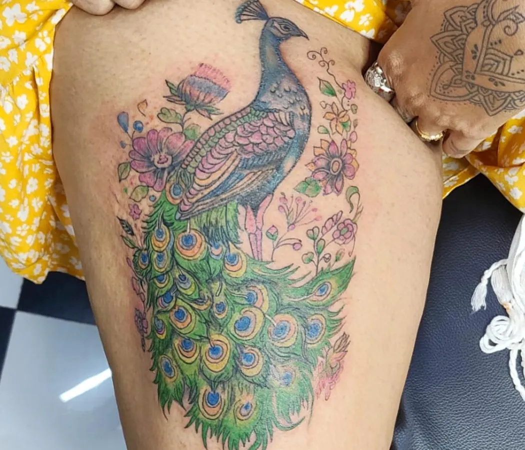 A royal peacock tattoo is a symbol of beauty and pride. I love working with color to create vibrant, timeless masterpieces like this one. We designed this piece to flow perfectly on the thigh, making it a bold and elegant statement.