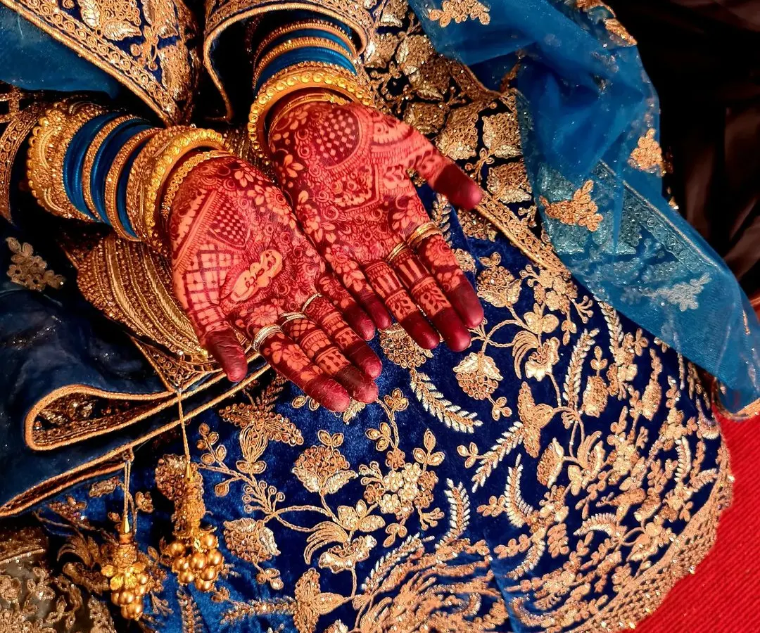 This is the beautiful, rich stain that develops from my 100% organic, chemical-free henna cones. The deep reddish-brown color, seen here against a bride's ornate blue lengha, is the result I always strive for.