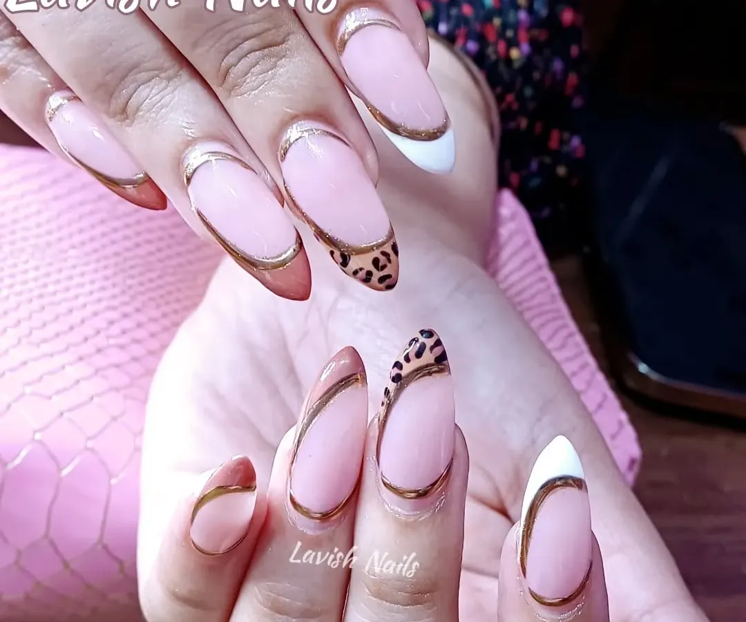 A modern twist on the French manicure, these almond-shaped nails feature a sharp design with gold chrome outlines, a classic white tip, and a bold leopard print accent nail. This look combines multiple techniques for a trendy, high-fashion result.