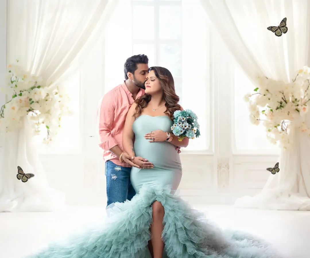 Capturing the love that started it all. Here, we created a dreamy, light-filled scene for this couple's maternity portrait. The soft mint green gown and ethereal butterflies add a touch of magic, perfectly framing the tender connection between the parents-to-be.