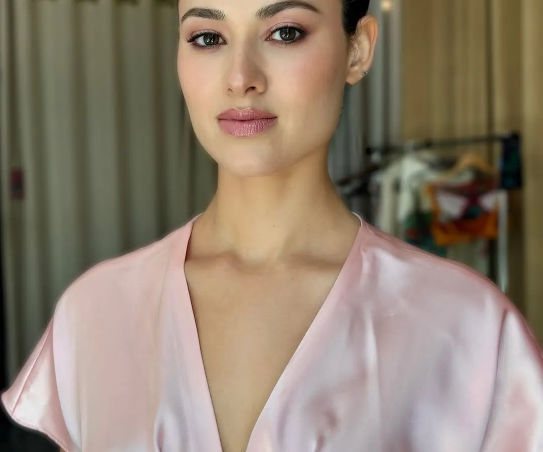 My philosophy is skin first, always. This portrait is completely raw and unedited, showcasing how the right skin work creates a luminous glow that looks incredible on camera without heavy editing. The look is minimal, with a soft pink wash on the eyes and lips, and a clean, sharp bun for a polished feel.
