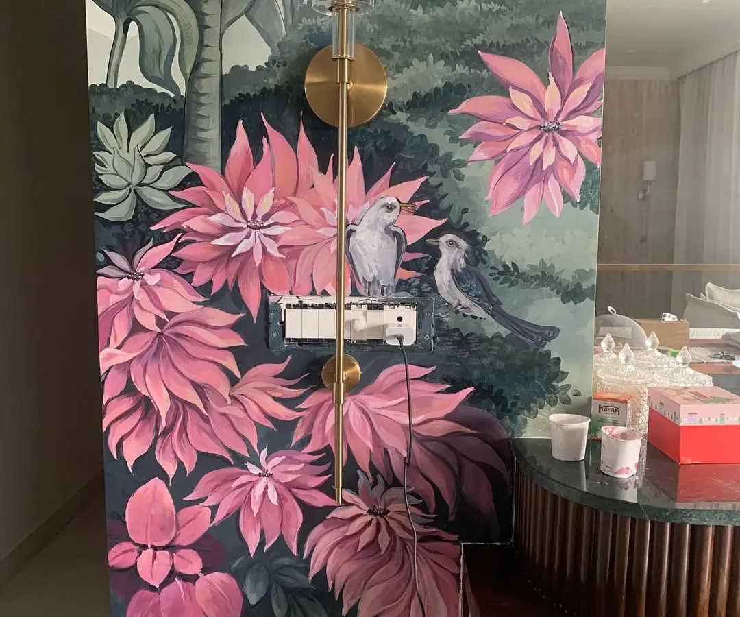 Here is a finished hand-painted nature mural that turns a living space into a tropical escape. We carefully paint around existing features like light fixtures and switches to make the art feel like a natural part of your home.