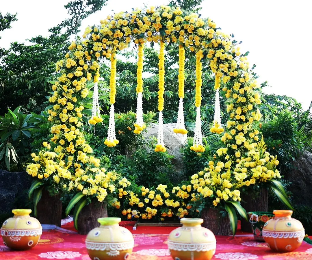 We bring vibrant traditions to life with this beautiful Haldi ceremony decor. A full circular arch made of bright yellow marigolds and contrasting white floral hangings creates a joyful and picture-perfect setting for pre-wedding festivities.