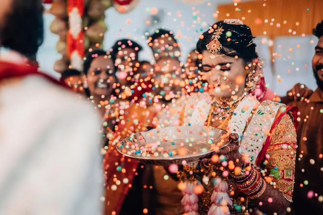 The pure, unscripted joy of a wedding ritual. We live for these candid moments, capturing the vibrant colors and infectious laughter that make your celebration truly unforgettable.