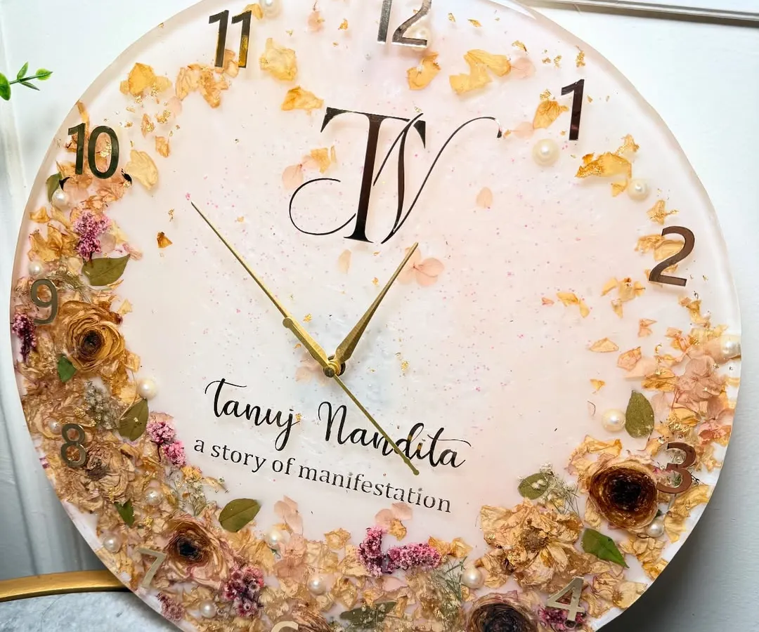Turn your wedding flowers into a timeless piece for your home. This 16-inch custom resin wall clock was made by preserving a couple's special varmala. I carefully arranged the dried flowers and personalized it with their initials and names, creating a functional piece of art that tells their story.