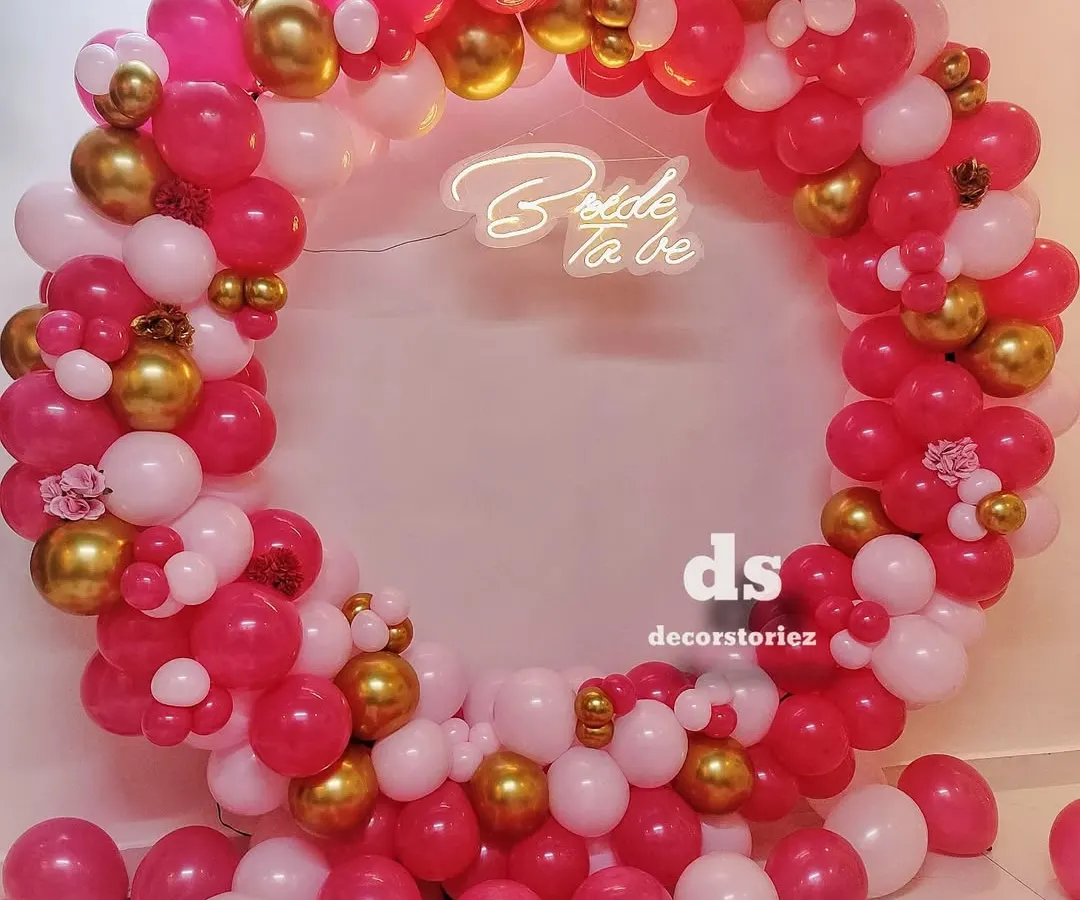 This full-ring balloon backdrop is one of our most requested items for bridal showers. We created this look with a vibrant mix of pink, white, and gold balloons, centered around a custom 'Bride to be' neon sign for the perfect photo opportunity.