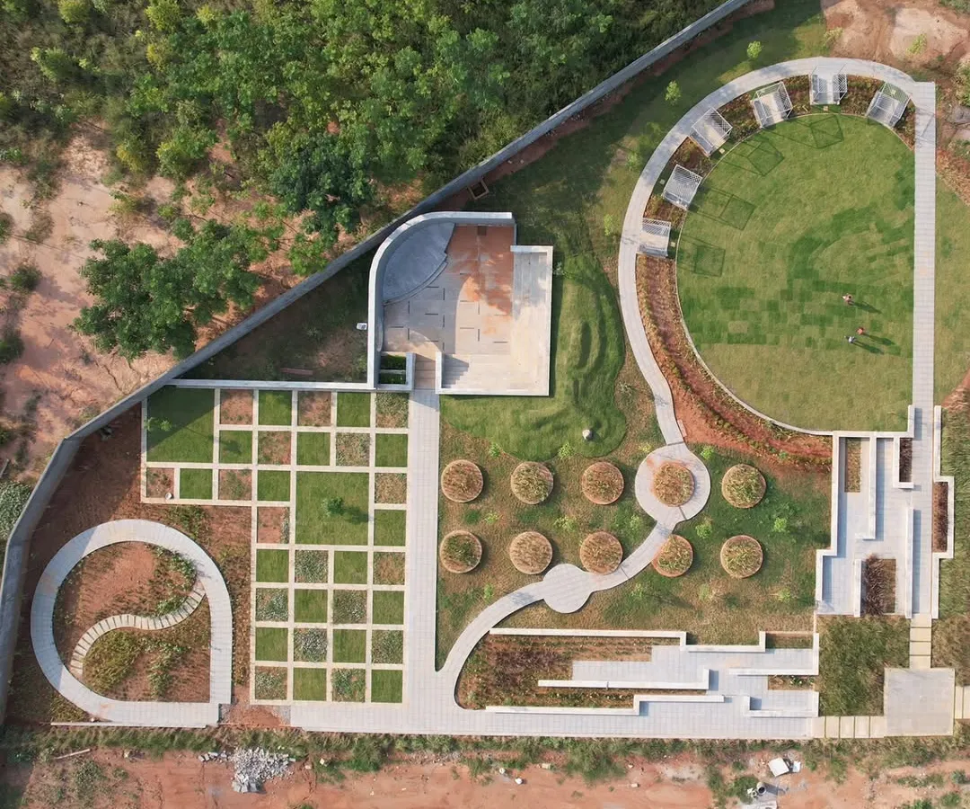 An aerial view of a community park nearing completion. This shows our approach to master planning, where we sculpt the land to create a variety of experiences, from open lawns and amphitheaters to intimate garden paths and gridded groves.