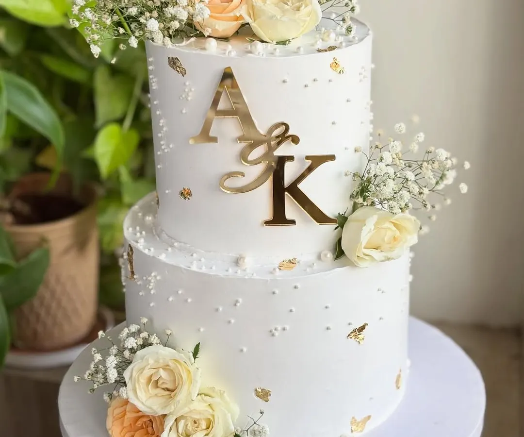 When love is golden. ✨ I designed this timeless two-tier engagement cake with delicate fresh florals, soft pearls, and hints of gold leaf. It’s perfect for whispering “she said yes” in the most graceful way.