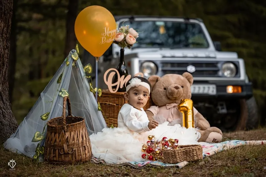 A first birthday celebration set against the beautiful backdrop of the Shimla hills. I arrange these outdoor milestone sessions to feel like a fun family picnic, complete with a custom setup including a tent, balloons, and a teddy bear.