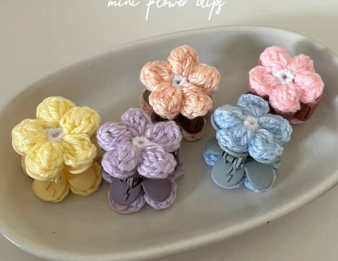 These are my mini flower clips, perfect for adding a pop of color. Each one is handmade and attached to a snap clip, available in pastel shades like yellow, lavender, peach, blue, and pink. They are great for pinning back bangs or decorating braids.