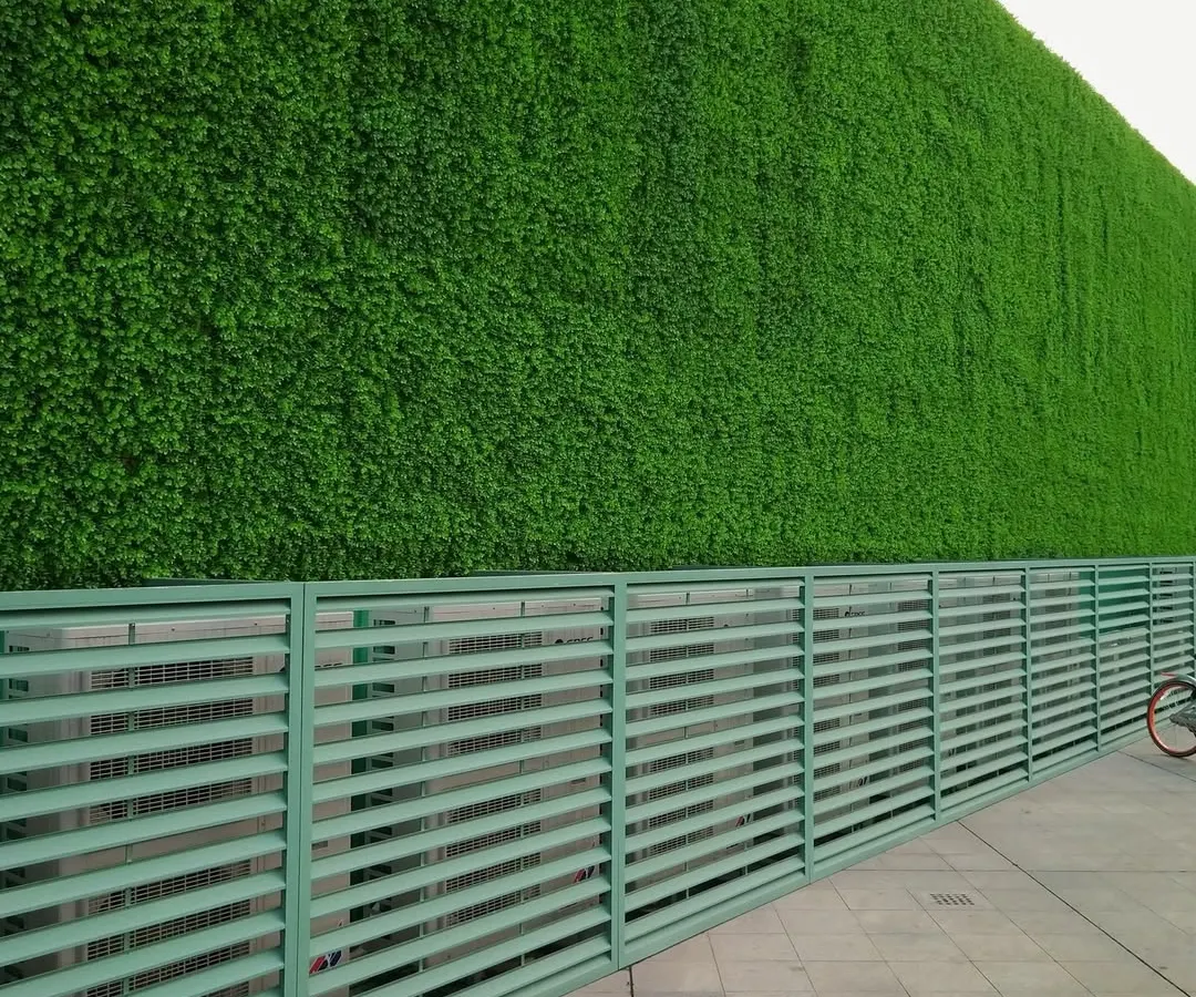 This large-scale commercial installation showcases a massive artificial green wall, creating a striking and modern exterior facade. The high-quality, UV-resistant turf ensures the building stands out with vibrant, year-round greenery, perfect for corporate offices or public buildings in Bangalore.