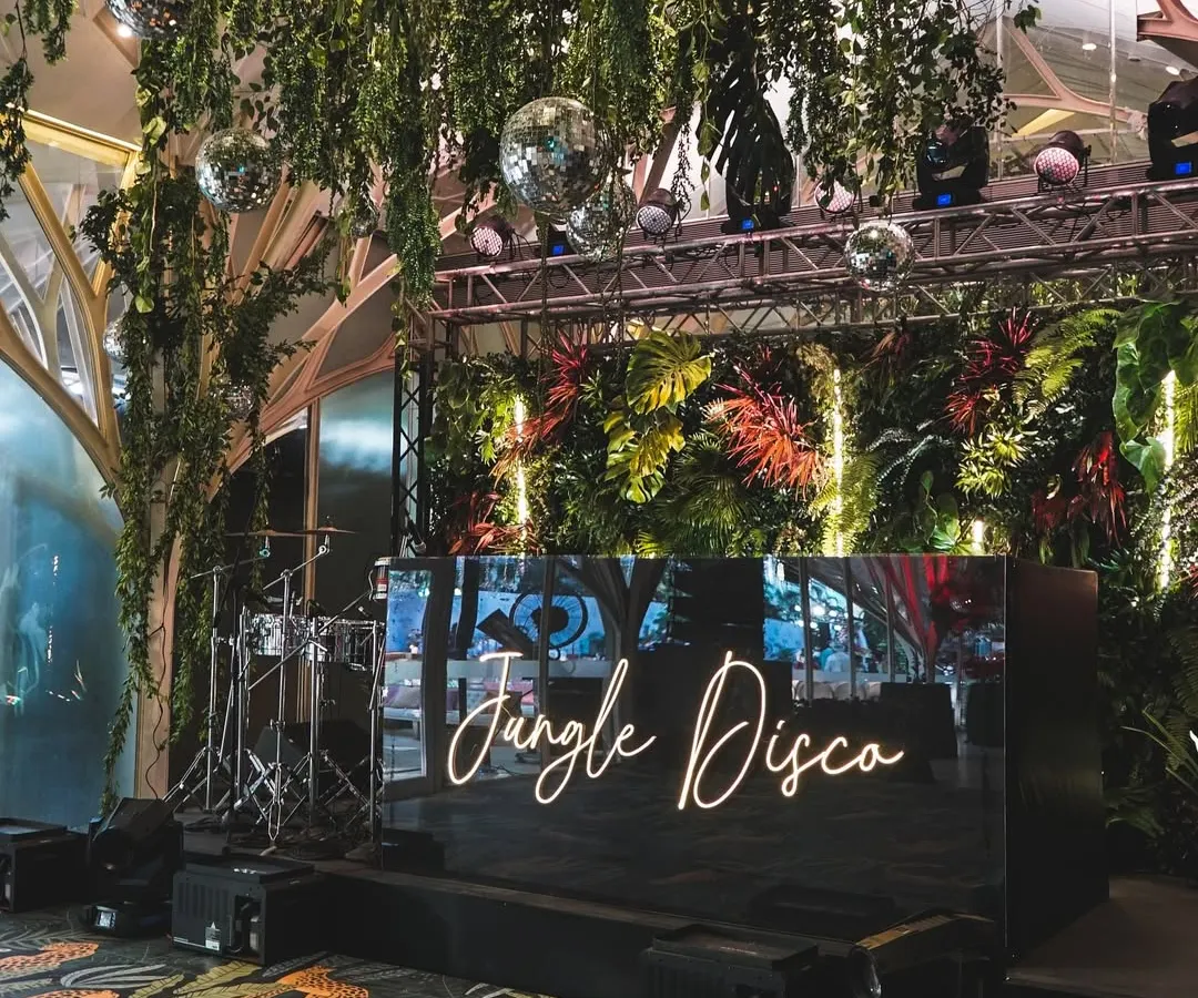 For a couple who wanted to dance the night away, we created a 'Jungle Disco' reception. This theme combined lush greenery with the vibrant energy of disco, featuring a custom neon sign, sparkling disco balls, and a dance floor that invited everyone to let loose.